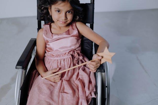 A girl in a fairy costume sat in a wheelchair