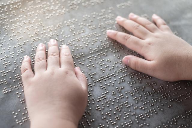 Child hands reading braille