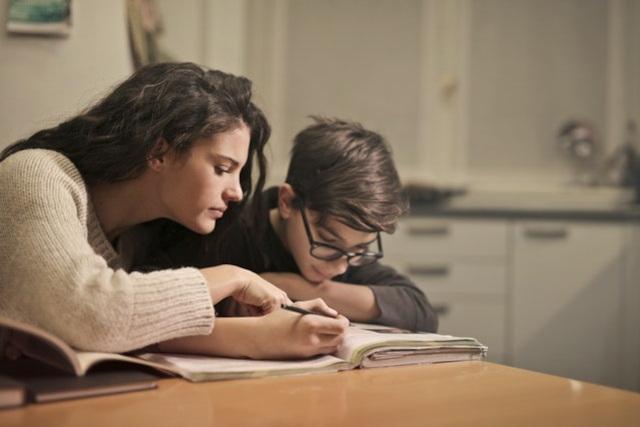 A woman helping a child with his homework