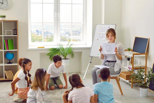 female school psychologist talks about emotions during meeting with group of children